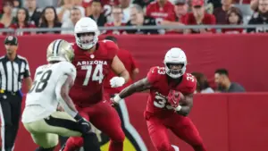 74755639007-uscp-7-wor-74-oorwp-19-xcuh-4-y-2-original Trey Benson, Arizona Cardinals running back, running through the line of scrimmage.