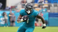 Travis Etienne, Jacksonville Jaguars running back, running through the line of scrimmage.